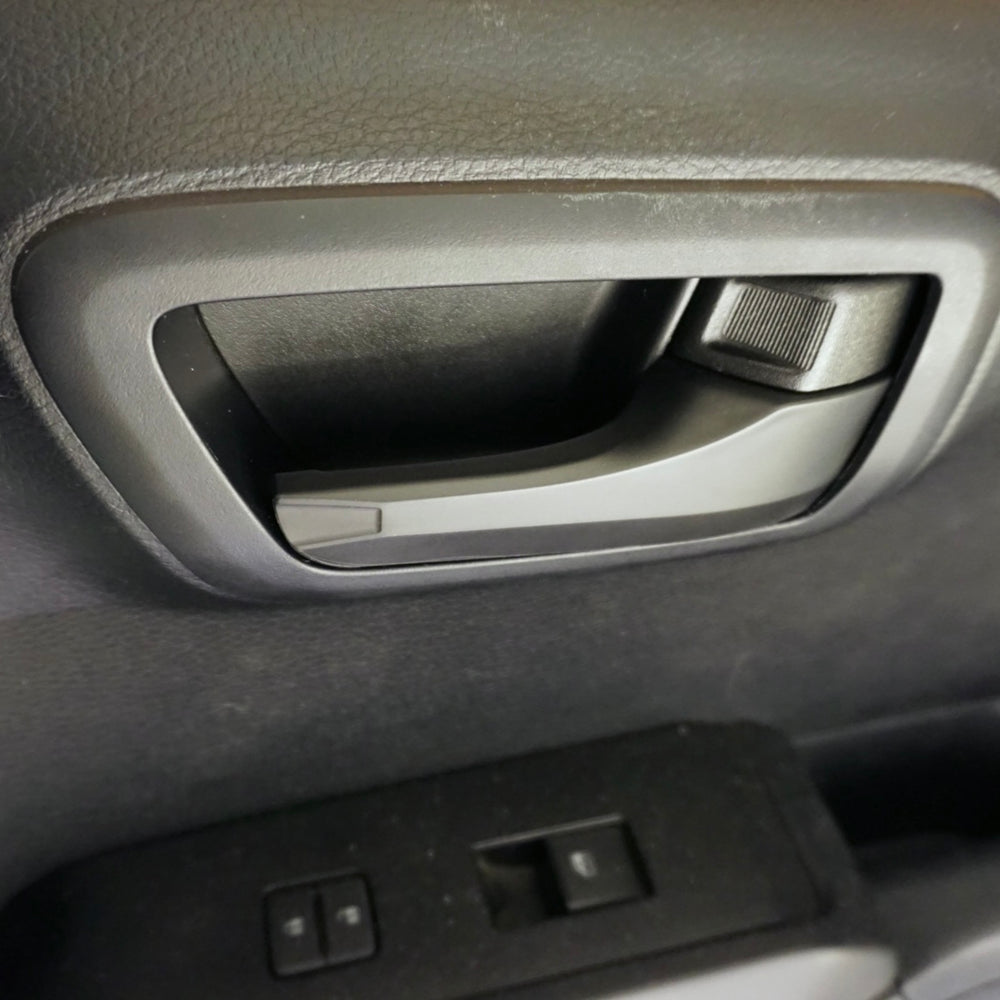 Door handle cover installed on a Tacoma door panel above the window switches