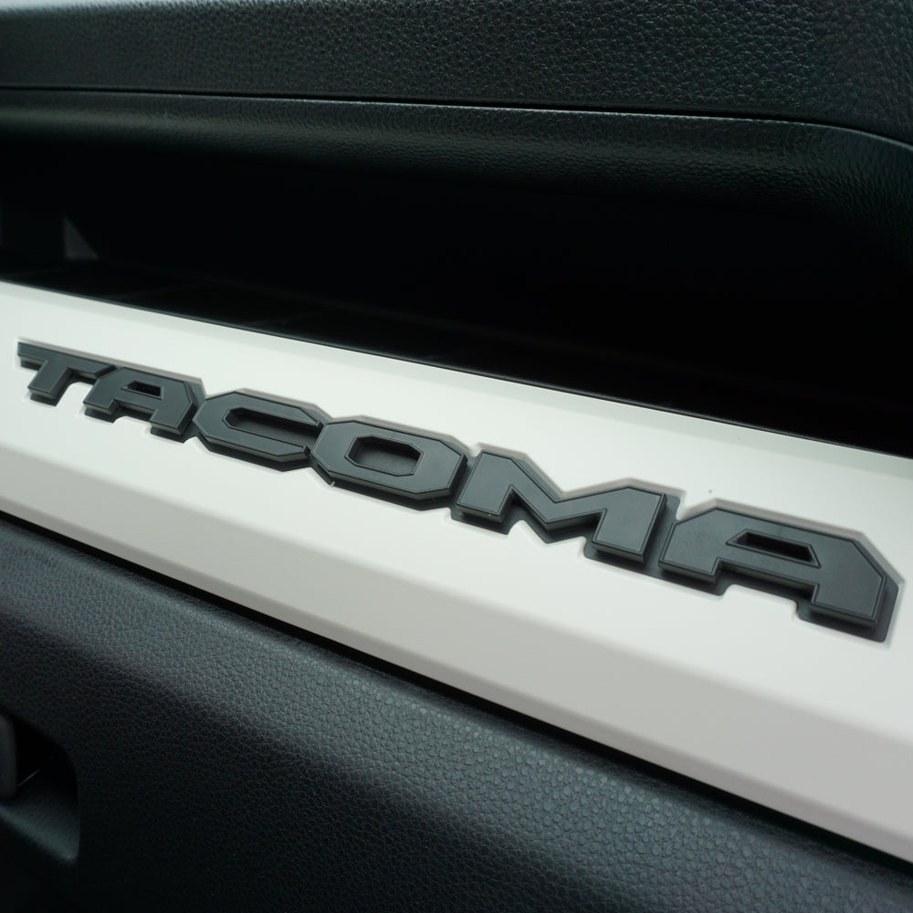 AJT Design matte glovebox letters installed on the dash of a 2024+ Toyota Tacoma