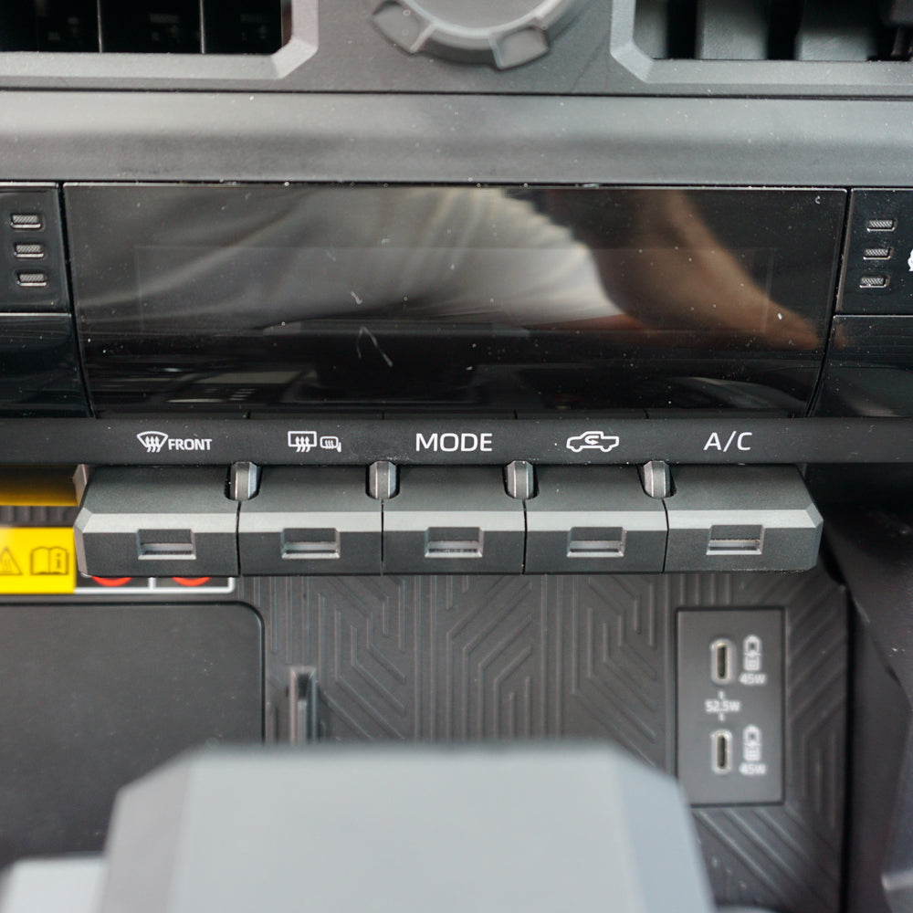 AJT Design toggle covers installed on the climate controls of a 2024+ Toyota Tacoma, also fits the 2025+ Toyota 4Runner