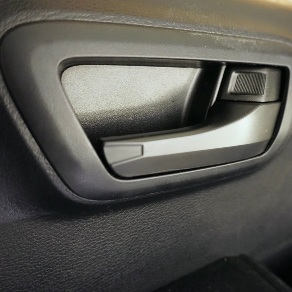 AJT Design door handle cover installed on the interior door handle of a 2016-2023 Toyota Tacoma