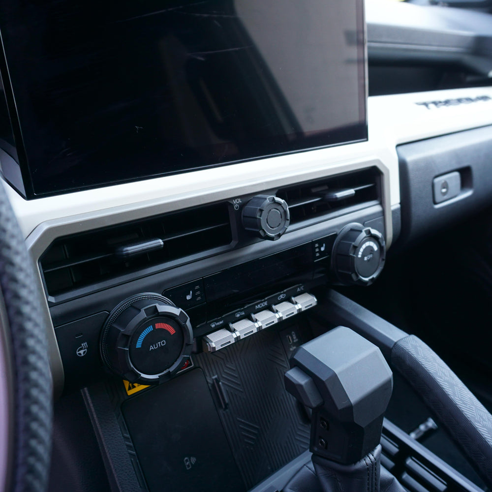 AJT Design V2 radio and climate knobs installed below the touchscreen in a Toyota Tacoma