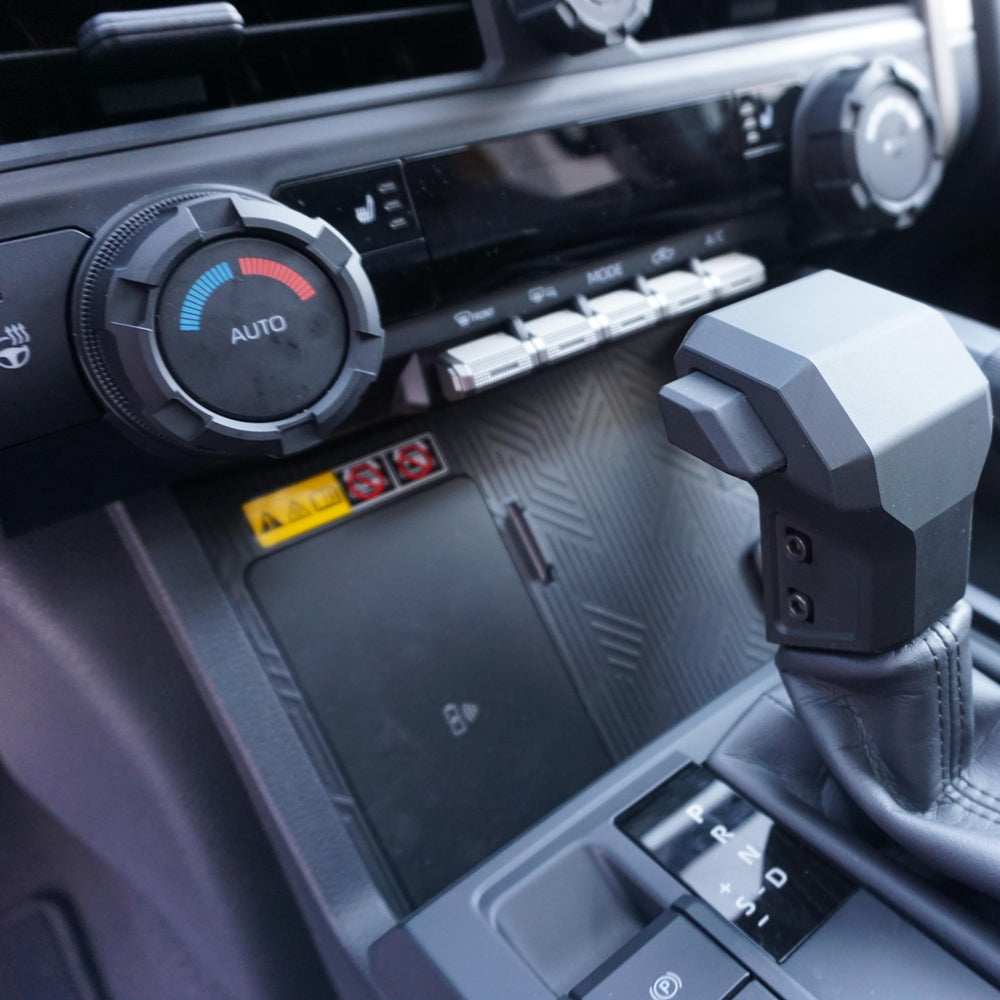 AJT Design V2 climate knob installed above the shifter in a Toyota Tacoma