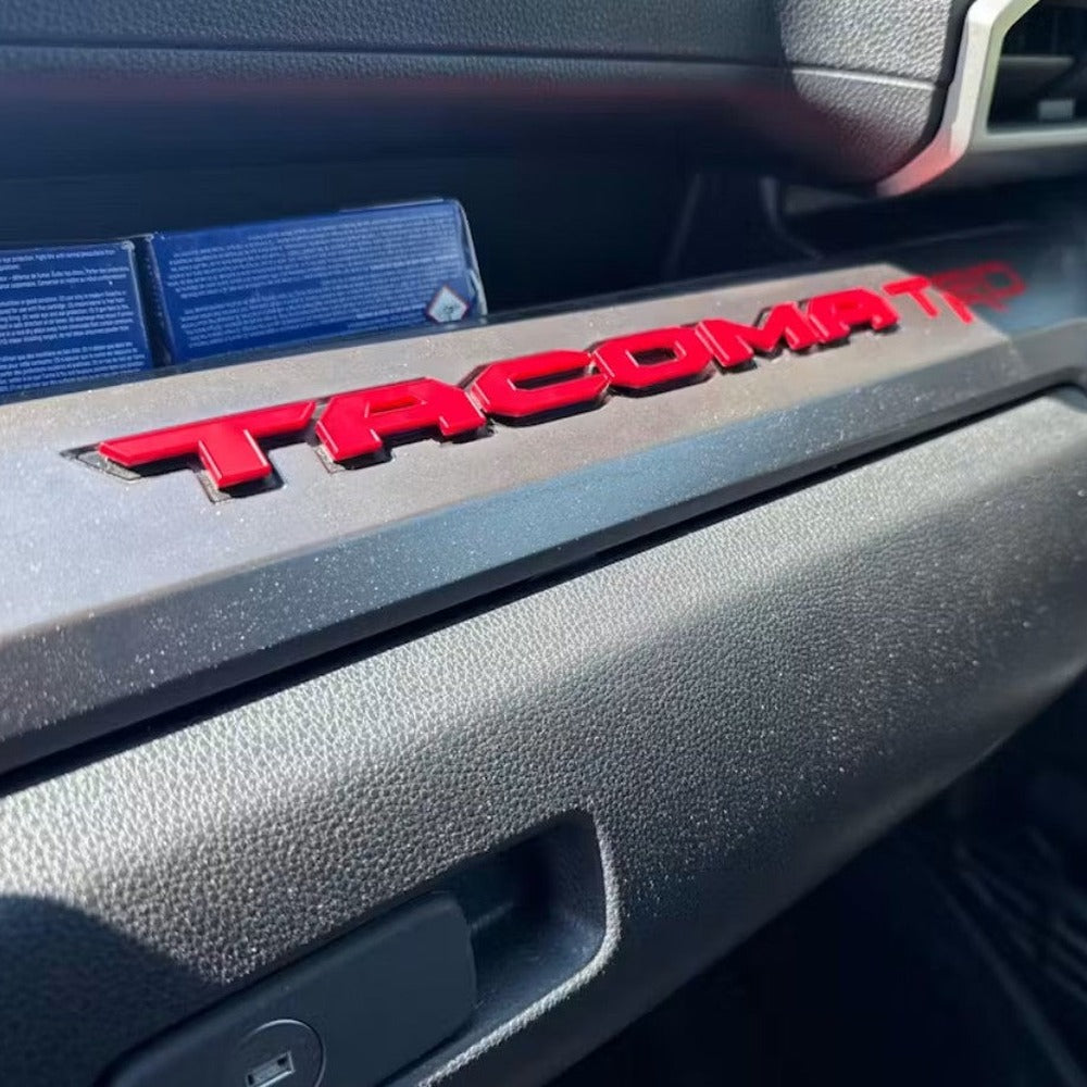 Red glovebox letters installed on a Tacoma dash