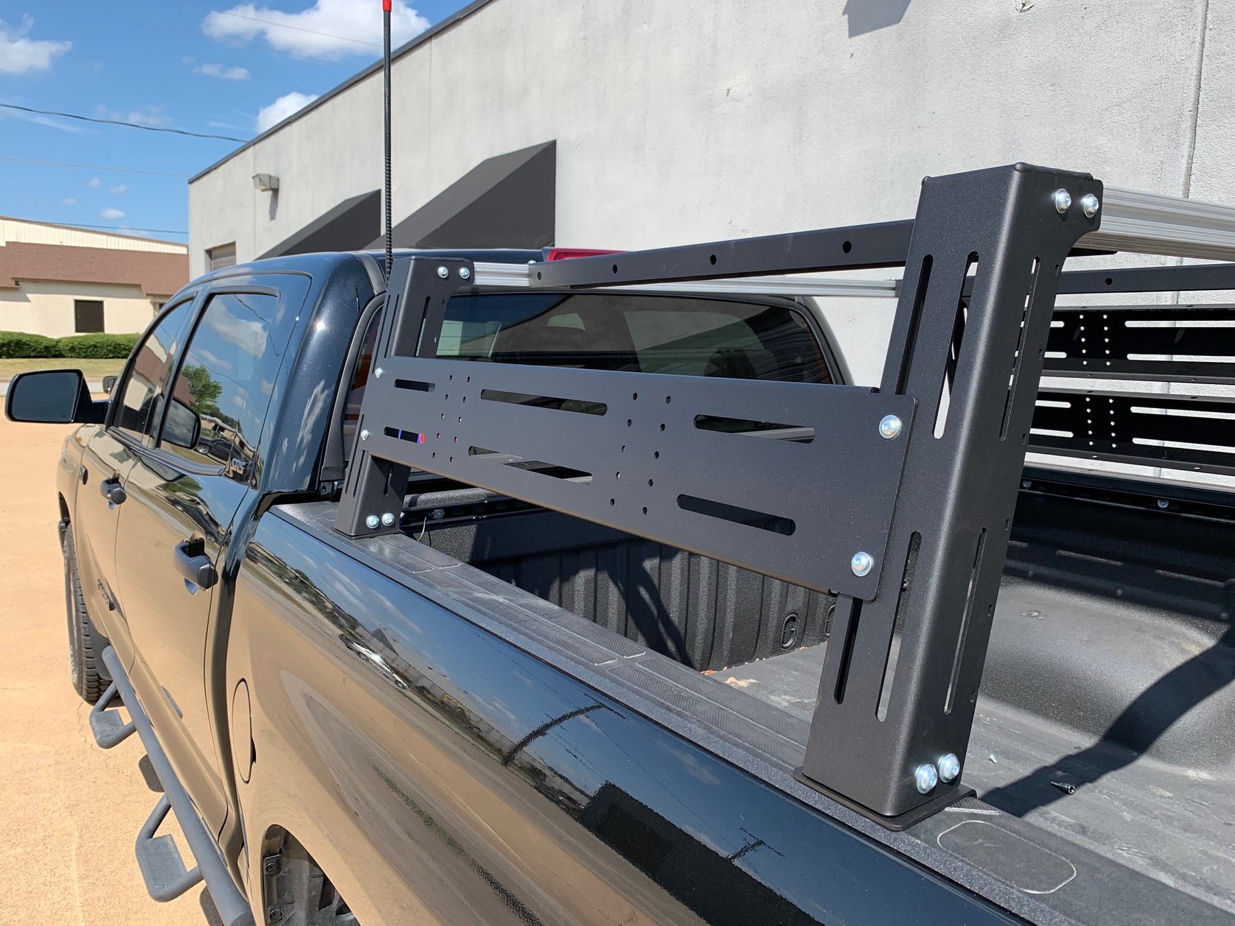 Close-up rear drivers side view of black Toyota Tundra with Overland Bed Rack - Cali Raised LED